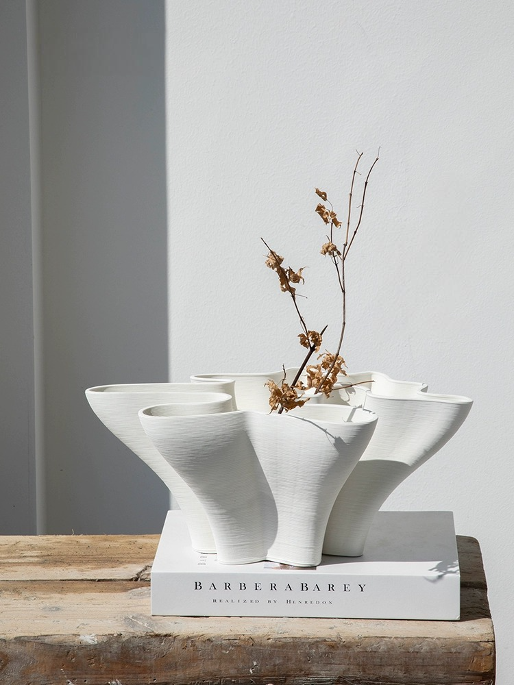 Modern abstract white ceramic vase with dry floral arrangement, minimalist home decor.